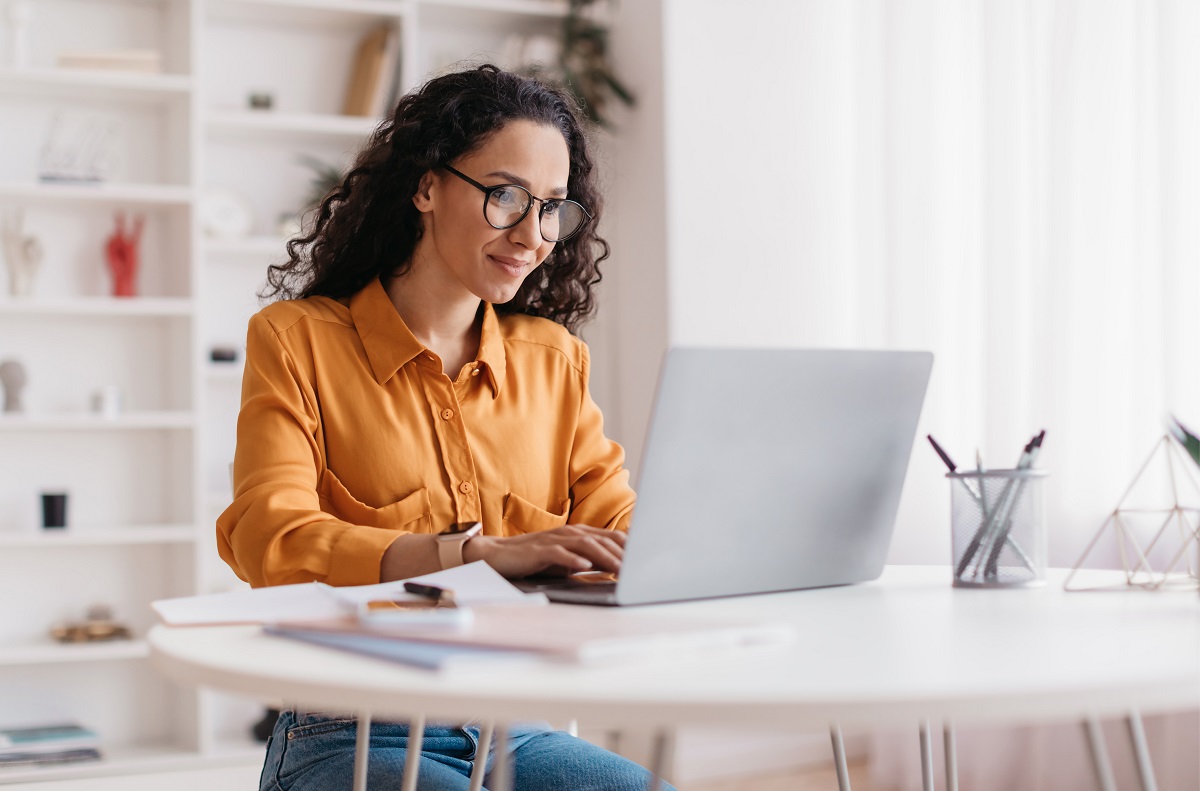 Une femme qui utilise un laptop, l'air intress par ce qu'elle voit  l'cran.