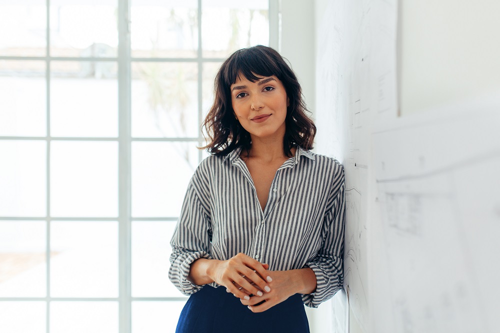 Femme d'affaires debout au bureau. Portrait d'une femme d'affaires confiante.