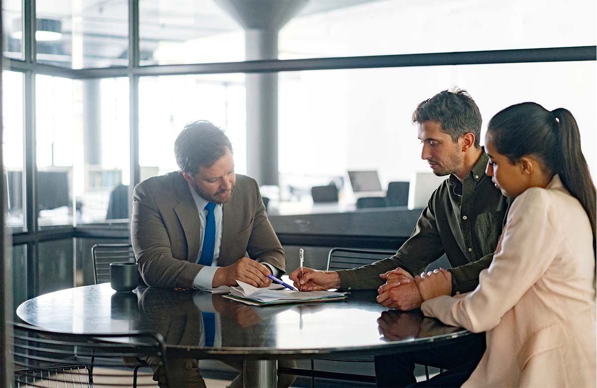 Image dcorative : Une femme et un homme discutent de leurs finances avec un conseiller financier.