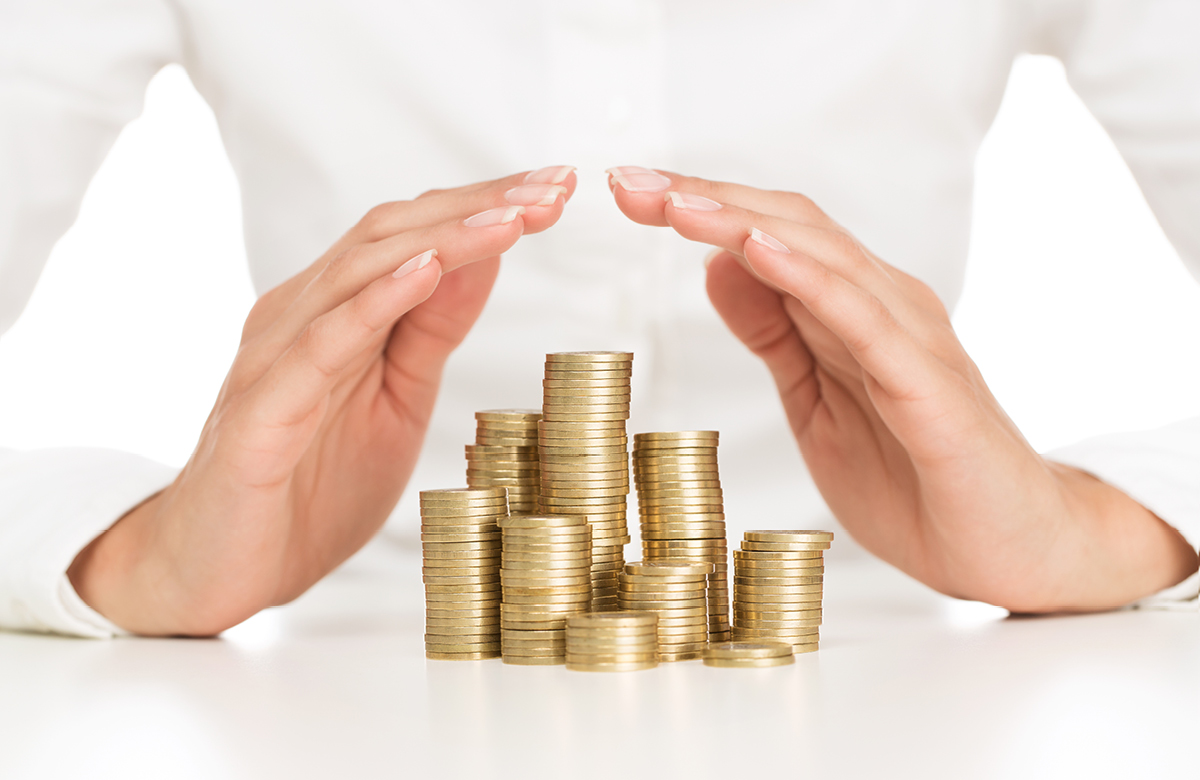 Hands covering a pile of coins.