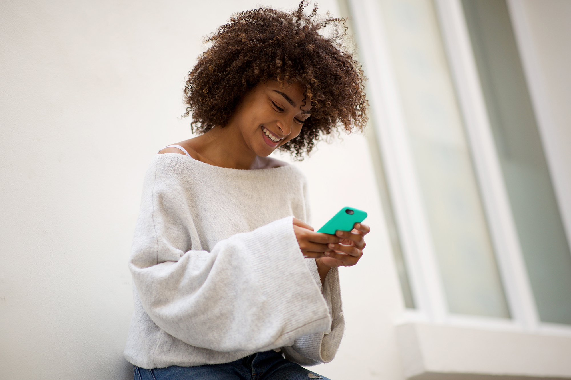 Young women smiling looking at a cellphone.